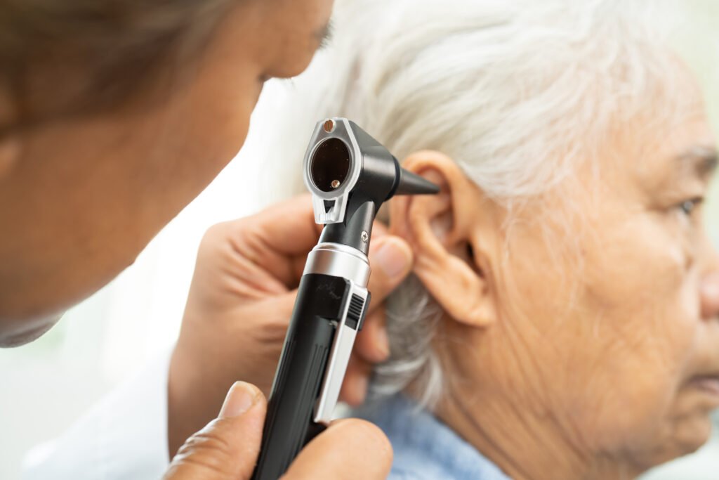 audiologist or ent doctor use otoscope checking ear of asian sen