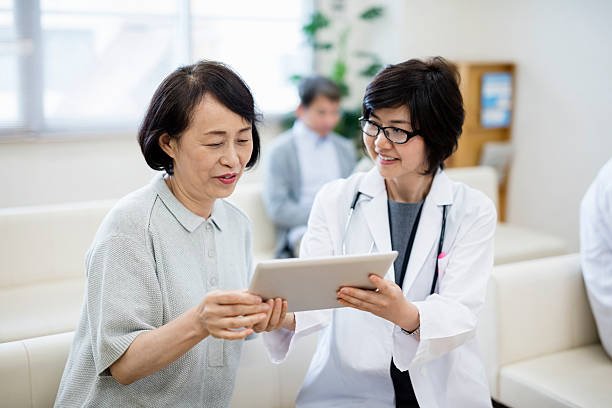 female doctor showing digital tablet to patient in hospital female doctor showing digital tablet to patient in hospital